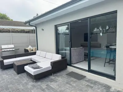 a patio with a couch and a table and glass doors at Lansdowne Lodge in Welton