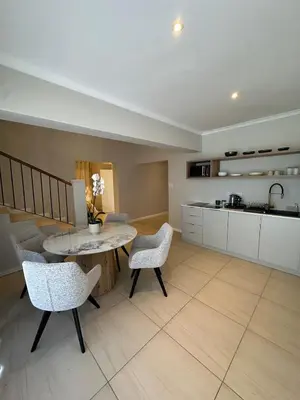 a kitchen and living room with a table and chairs at Little Nest in Somerset West