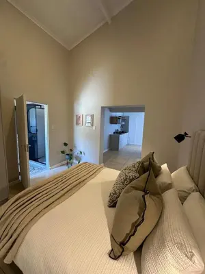 a bedroom with a large white bed in a room at Little Nest in Somerset West