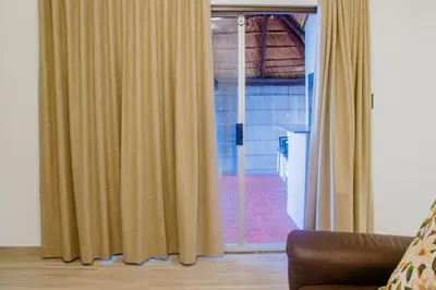 a living room with a window with curtains at Milino Guest House in Cape Town