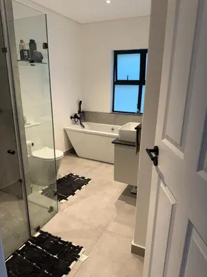 a bathroom with a shower and a toilet and a sink at Durbanville apartment in Durbanville