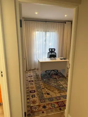 a room with a table and a chair on a rug at Durbanville apartment in Durbanville