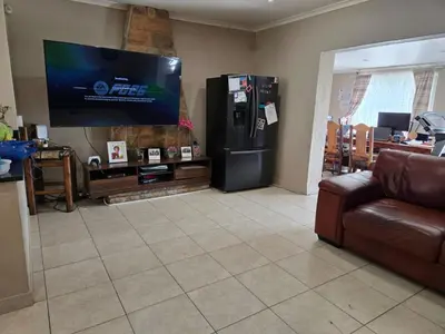 a living room with a large television and a couch at Nyati in Cape Town