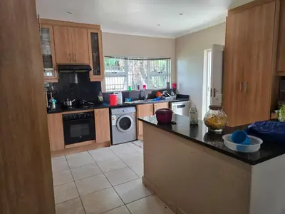 a kitchen with a refrigerator and a dishwasher at Nyati in Cape Town