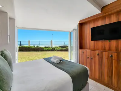 a bedroom with a bed and a large window at Seaside Serenity with Ocean View in Cape Town
