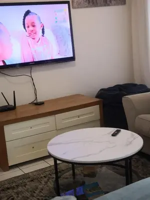 a living room with a flat screen tv on the wall at Duplex in Tableview in Cape Town