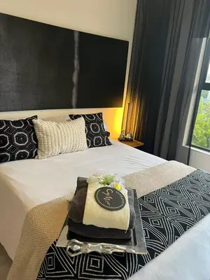 a hotel room with a tray on a bed at The Jade, Somerset West in Strand