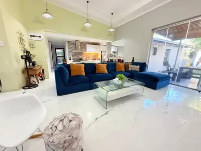 a living room with a blue couch and a table at Centrally located 11 sleeper house near Canal Walk in Cape Town