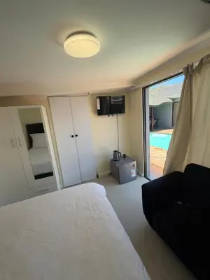 a bedroom with a bed and a view of a pool at Joy House in Cape Town