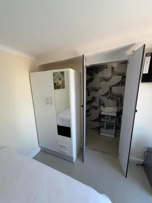 a bedroom with a white bed and a mirror at Joy House in Cape Town