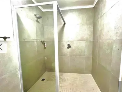 a shower with a glass door in a bathroom at Luxe Manhattan Quarters in Cape Town