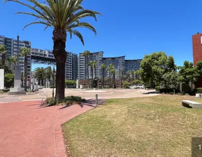a palm tree in a park with buildings in the background at Luxe Manhattan Quarters in Cape Town