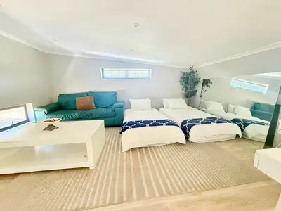 a living room with two beds and a couch at Spacious house for 11 Guests near Canal Walk Mall in Cape Town