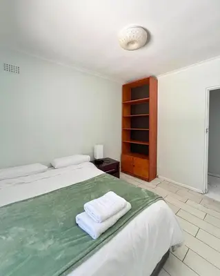 a white bedroom with a bed with towels on it at Spacious house for 11 Guests near Canal Walk Mall in Cape Town