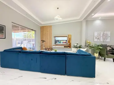 a large blue couch in a living room at Spacious house for 11 Guests near Canal Walk Mall in Cape Town