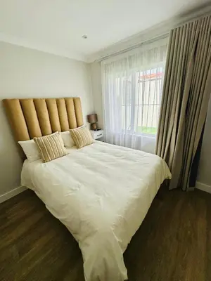 a bedroom with a large bed with a large window at Spacious Family Friendly Richwood in Cape Town