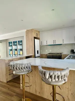 a kitchen with a counter with two bar stools at Spacious Family Friendly Richwood in Cape Town
