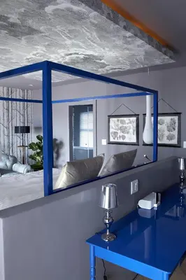 a mirror above a blue desk in a bedroom at Majeka House Boutique Hotel by The Living Journey Collection in Stellenbosch