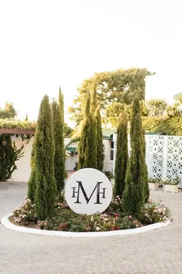 a sign with the word m in the middle of trees at Majeka House Boutique Hotel by The Living Journey Collection in Stellenbosch