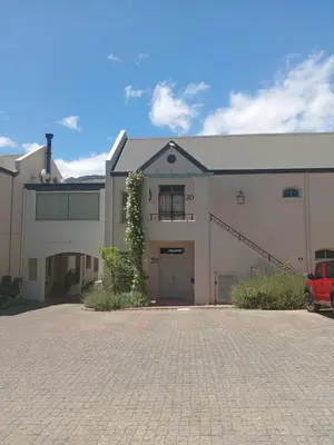 a large white building with a red car parked in front at L'Ermitage Villa Francois in Franschhoek