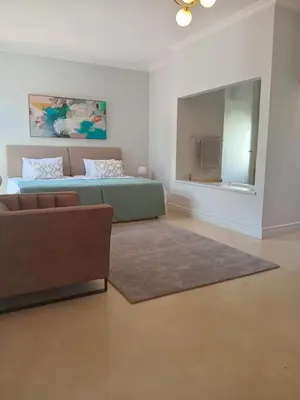 a bedroom with a bed and a couch and a mirror at L'Ermitage Villa Francois in Franschhoek