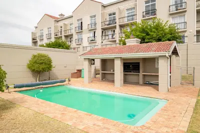 a swimming pool in front of a building at Belina - Century On Lake Moorings in Cape Town