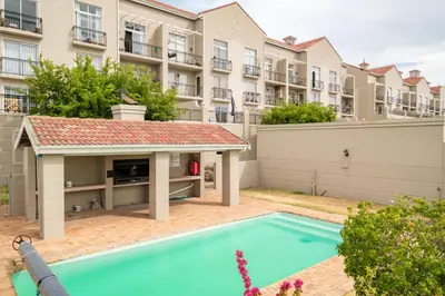 a swimming pool in front of a building at Belina - Century On Lake Moorings in Cape Town