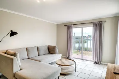 a living room with a couch and a table at Belina - Century On Lake Moorings in Cape Town