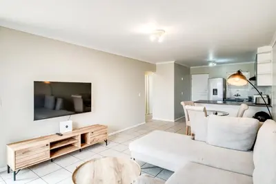 a living room with a couch and a table at Belina - Century On Lake Moorings in Cape Town