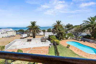 a view from the balcony of a house with a swimming pool at Gordons Village View in Cape Town