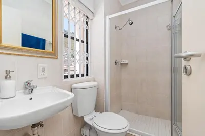 a bathroom with a toilet and a sink and a shower at Gordons Village View in Cape Town