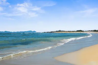a beach with the ocean and a sandy shore at Gordons Village View in Cape Town