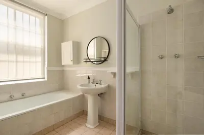 a bathroom with a sink and a mirror and a shower at Story Haus in Stellenbosch