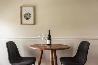 a table with two chairs and a bottle of wine at Story Haus in Stellenbosch