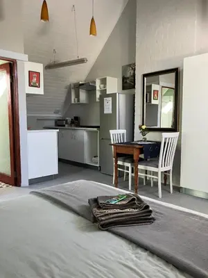 a living room with a table and a kitchen at Starry Starry Night Loft, with Aircon in Die Boord in Stellenbosch