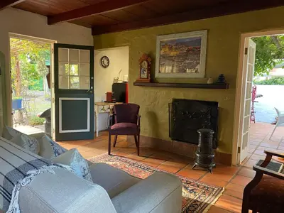 a living room with a couch and a fireplace at Maggie Rose Self Catering Cottage in Greyton