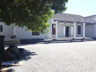 a brick courtyard with a building and a tree at Edion Royal Guesthouse in Cape Town