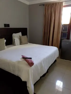 a bedroom with a large white bed and a window at Edion Royal Guesthouse in Cape Town
