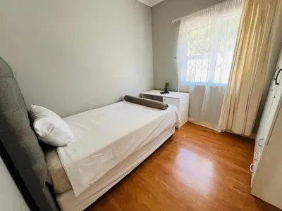 a bedroom with a white bed and a window at 4 Bedroom Bliss in Cape Town