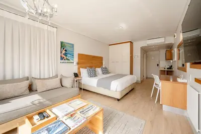 a bedroom with a bed and a living room at Harbour House Hotel in Hermanus