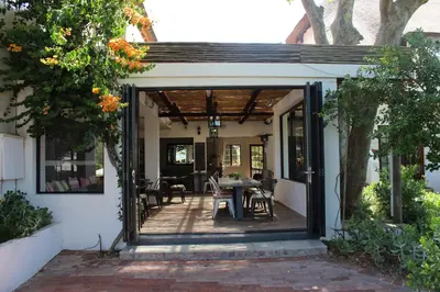 an open door to a patio with a table and chairs at Wedgeview Country House & Spa in Stellenbosch