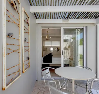 a dining room with a white table and chairs at Silencio in Hermanus