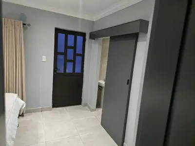 a bathroom with a black door and a window at Rachel`s Apartments - Stepney Crescent in Cape Town