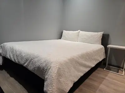 a bed with white sheets and pillows in a room at Rachel`s Apartments - Stepney Crescent in Cape Town