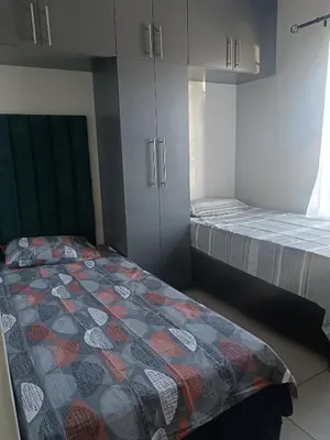 a room with two beds and cabinets in it at Belhar Lofts in Belhar