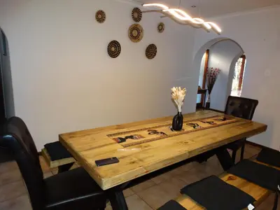 a dining room table with a vase of flowers on it at African Oasis Morrocco in Somerset West