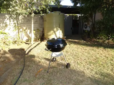 a charcoal grill on a stand in a yard at African Oasis Morrocco in Somerset West