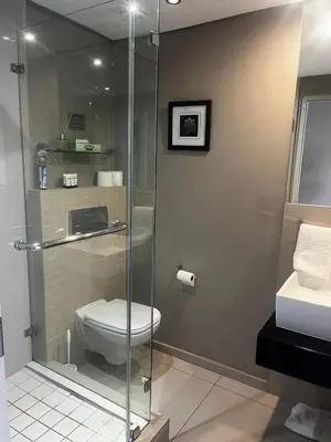 a bathroom with a shower with a toilet and a sink at Aquarius Luxury Suites 406 in Cape Town