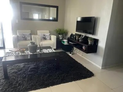 a living room with a coffee table and a tv at Aquarius Luxury Suites 406 in Cape Town