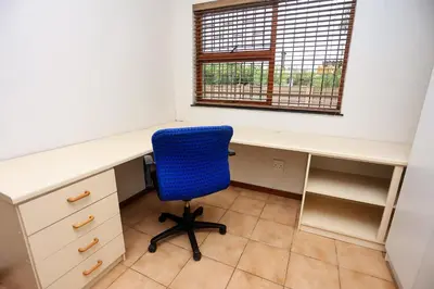 an office with a desk and a blue chair at African Oasis Zambia in Somerset West